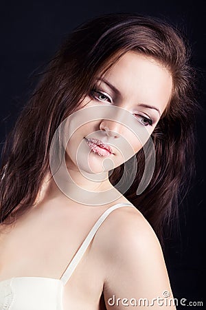 Beautiful young sexy girl brunette with makeup in the white bodysuit in the Studio on a black background