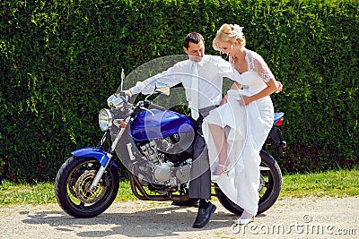 Beautiful young wedding couple on motorcycle