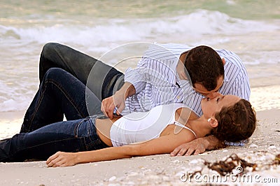 Beautiful young wet couple kissing on beach