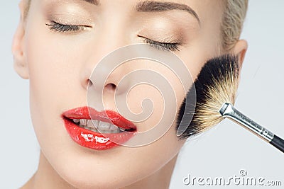 Beautiful Young Woman Applying Makeup with Brush