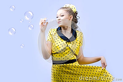 Beautiful young woman blowing soap bubbles