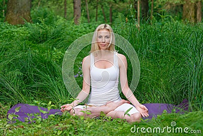 Beautiful young woman doing yoga outside