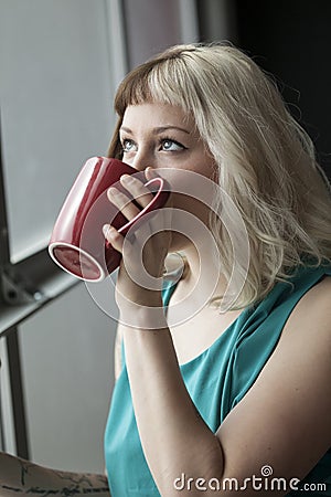 http://thumbs.dreamstime.com/x/beautiful-young-woman-drinking-red-coffee-cup-portrait-brown-blond-hair-also-holding-wearing-31292042.jpg