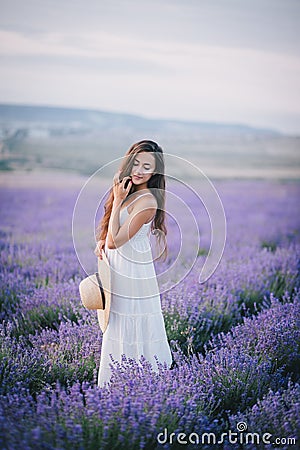 Beautiful young woman posing in a lavender field