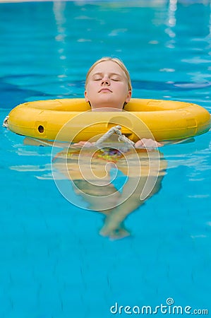 Beautiful young woman relax on life ring in pool in tropical bea