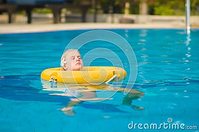 Beautiful young woman relax on life ring in pool in tropical bea