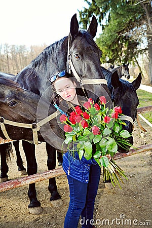 Beautiful young woman with roses and black horses