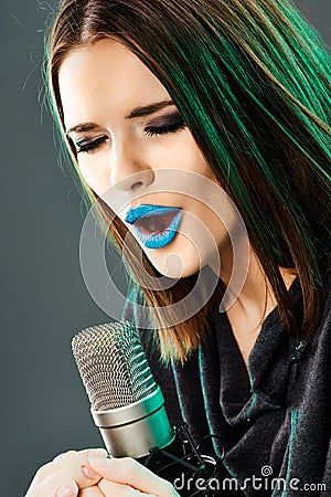 Beautiful young woman singer. Emotional teen girl