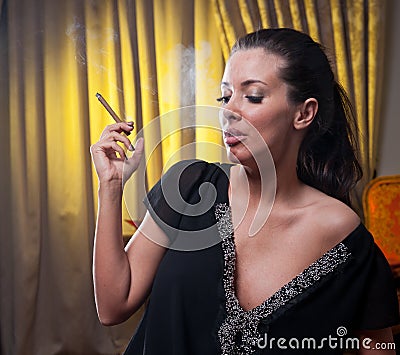 Beautiful young woman smoking a cigarette, thinkin