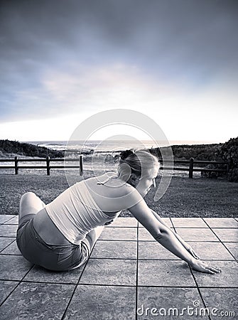 Beautiful young woman stretching at the sea