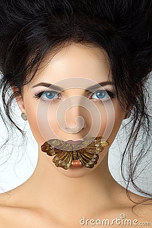 Beauty portrait of young woman with mouth covered with butterfly