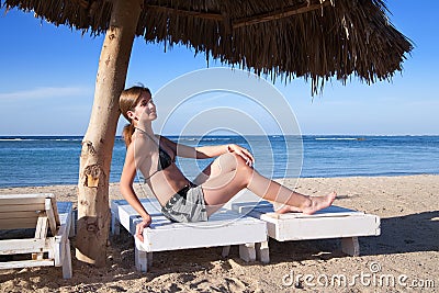 Beauty Woman in bikini sitting on the beach
