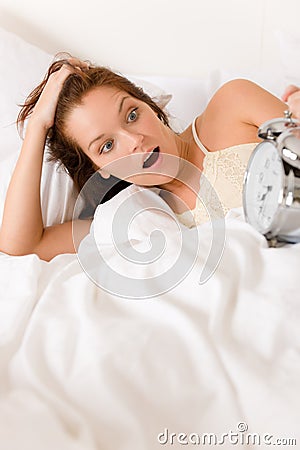 Bedroom surprise - woman with alarm clock wake up