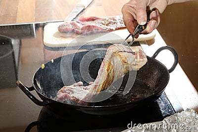 Beef with flour frying in pan