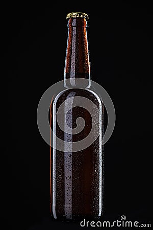 Beer bottle with water drops on black