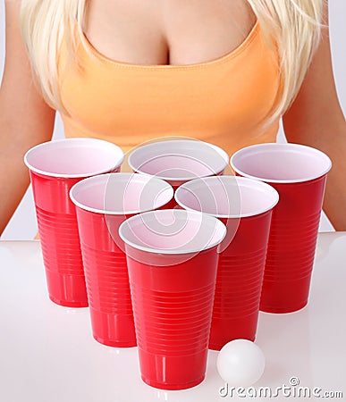 Beer pong. Red plastic cups with ping pong ball and blonde girl in sexy tank top