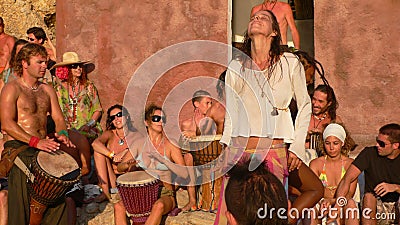 Benirras beach, Ibiza, Spain - July 23, 2006: Lots of people watching the sunset while playing drums and other instruments.