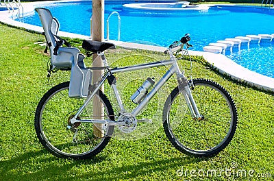 Bicycle with baby seat in grass pool outdoor