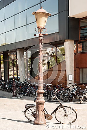Bicycle leaning against a street lamp