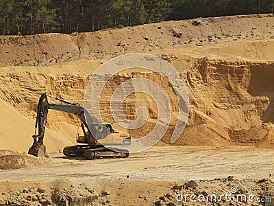 Big black orange digger in open sand mine is waiting for new shift.