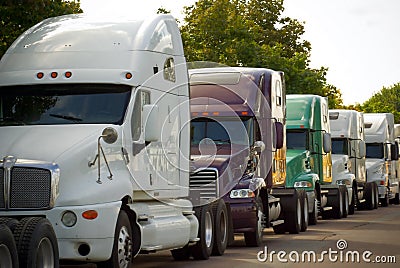 Big commercial transportation trucks lined on road