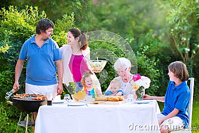 Big family grilling meat for lunch with grandmother
