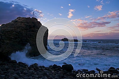 Big rock with waves during sunset