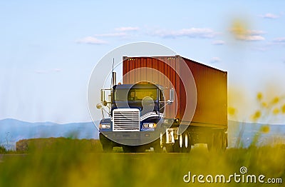 Big truck with container view through yellow flowers