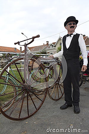 Biker holding an old bicycle.