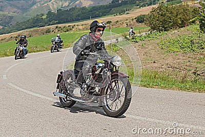 Biker rides an old Moto Guzzi of the thirties