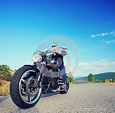 Biker riding a customized motorcycle on an open road
