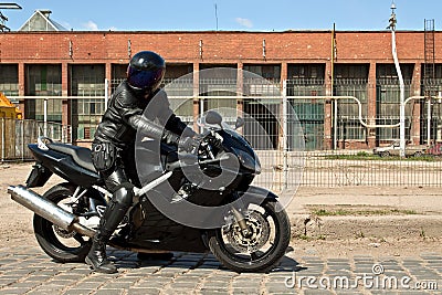 Biker riding motorcycle in old factory