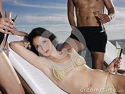 Bikini Woman Holding Champagne Glass With Friends By Ocean