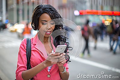 Black African American woman texting cellphone in city
