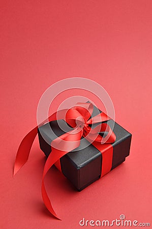 Black box romantic gift with red ribbon, vertical with copy space.