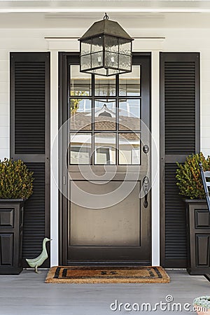 Black front door to a family home with porch