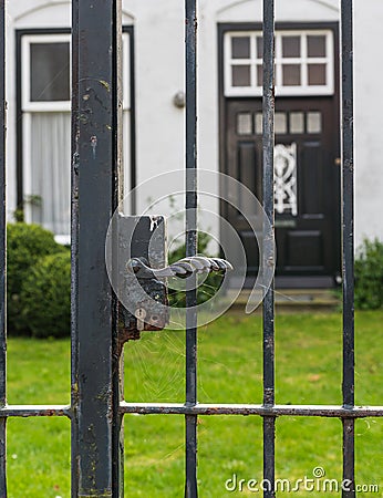 Black iron gate with rusty lock