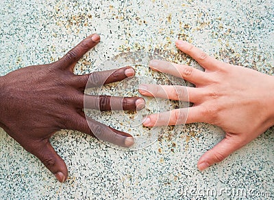 Black male and white female hands reaching