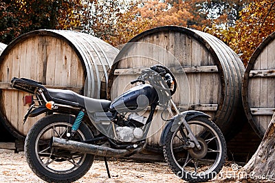 Black motorcycle on a background with a large barrel