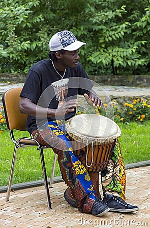 : Black musician from Africa demostrates how to play the drums