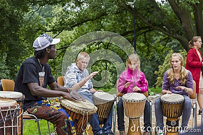 Black musician from Africa demostrates how to play the drums to