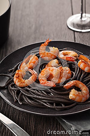 Black pasta with shrimps food on dark background