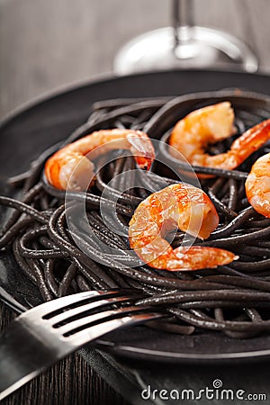 Black pasta with shrimps food on dark background