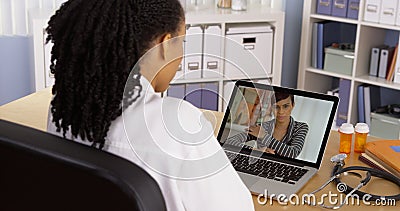 Black patient talking to doctor over laptop video chat