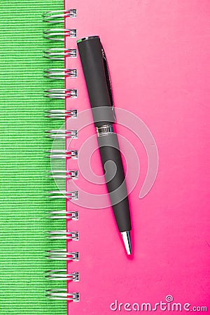 Black pen on pink notebook