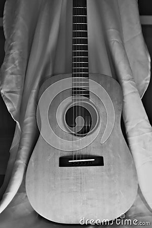 Black and White Acoustic Guitar Against a White Sh