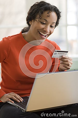 Black woman using credit card and laptop