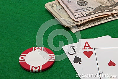 Blackjack hand with Dollar notes and chip on green