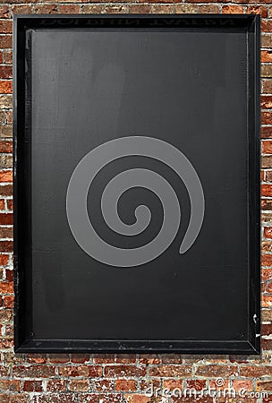 Blank blackboard menu sign on a red brick wall.