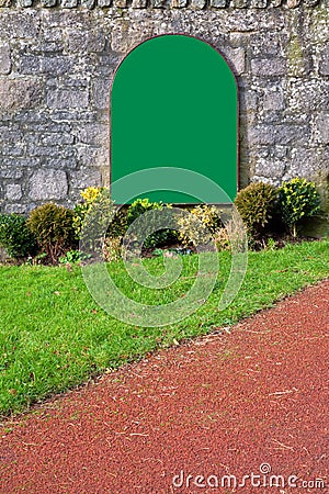 Blank green sign on an old stone wall